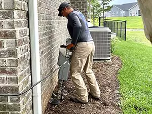 A technician applying termite treatments